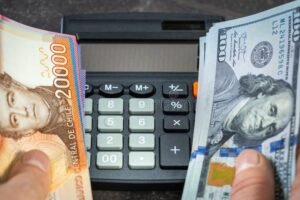 billetes chilenos junto a monedas y calculadora