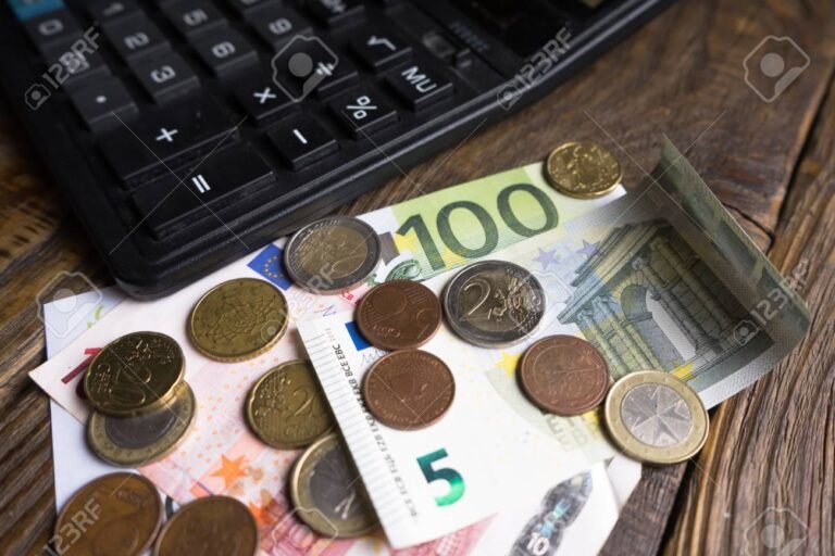billetes monedas y calculadora sobre mesa madera