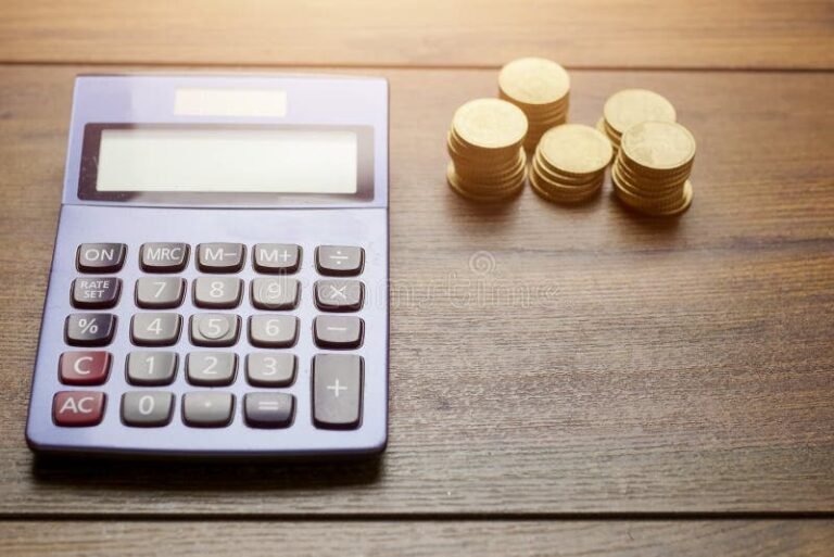 calculadora con billetes y monedas sobre mesa