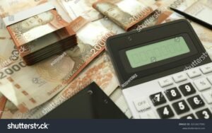 calculadora y billetes chilenos sobre mesa