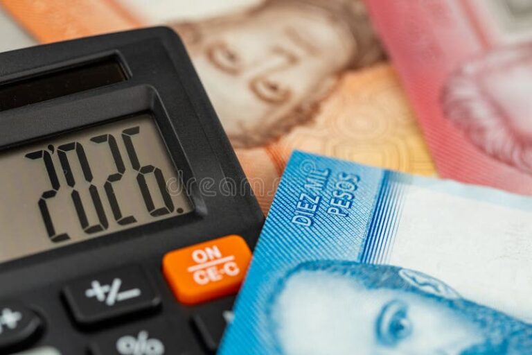calculadora y billetes chilenos sobre mesa madera