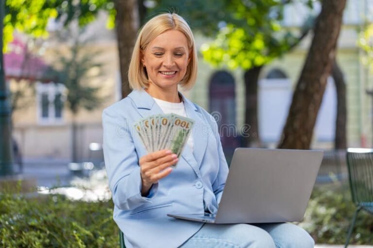 emprendedor feliz con billetes y laptop