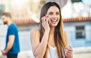 persona marcando telefono con sonrisa amable
