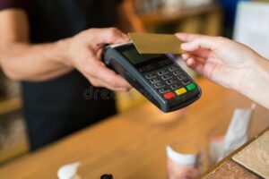 persona pagando con tarjeta en tienda moderna