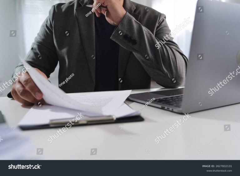 persona revisando documento con computadora portatil