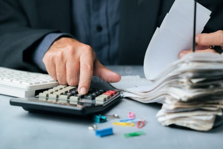 persona revisando documentos financieros y calculadora