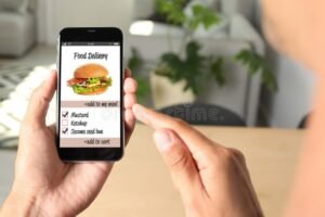 persona usando smartphone con comida y entrega